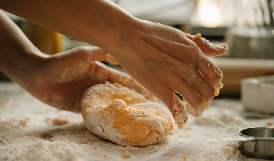 Woman kneading egg dough in bakery